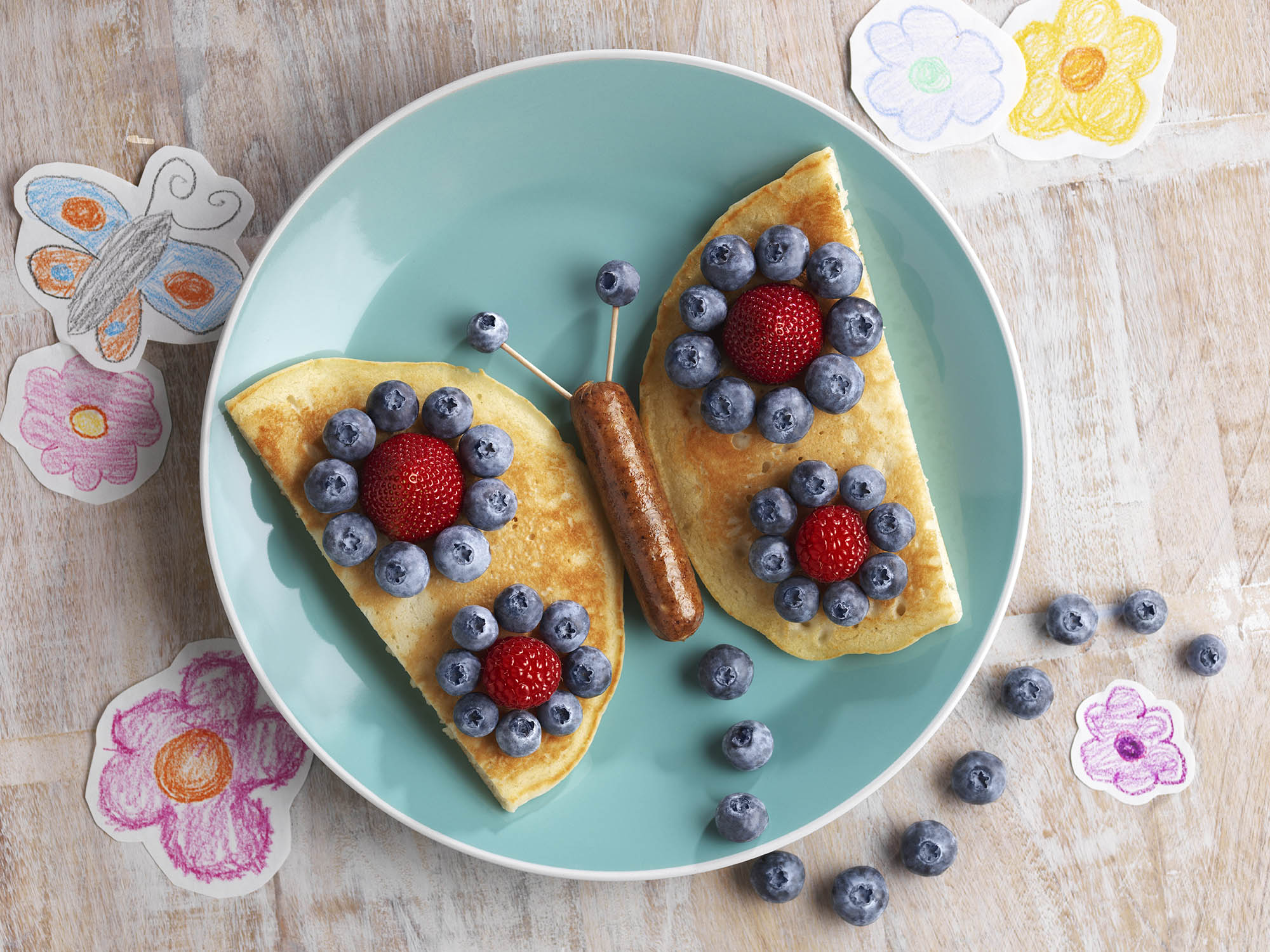 Plate with pancakes and berries in the shape of a butterfly 
