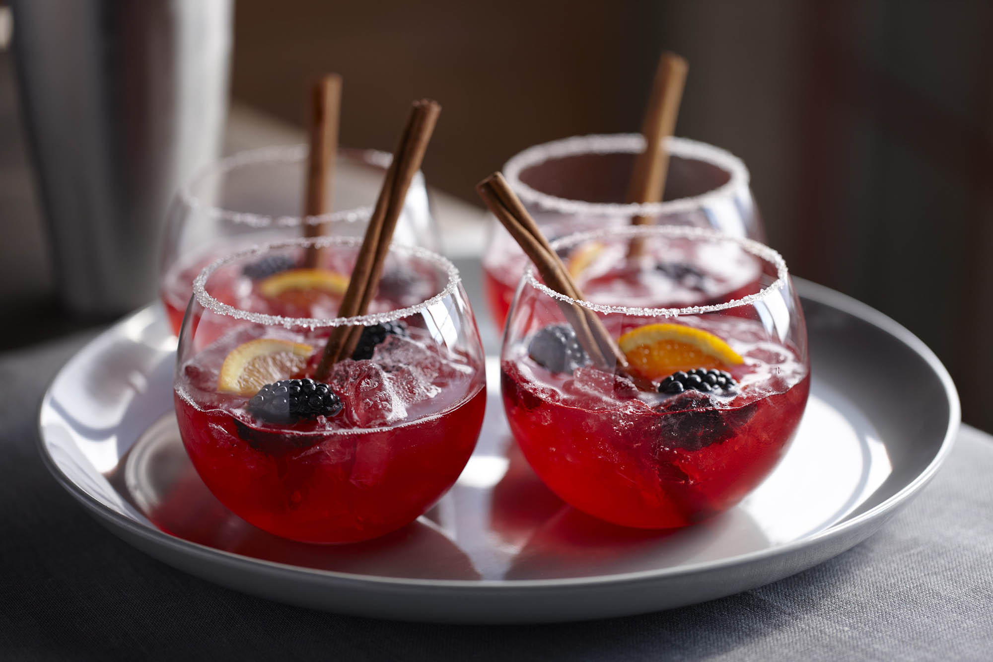 A tray with four cups of blackberry cider
