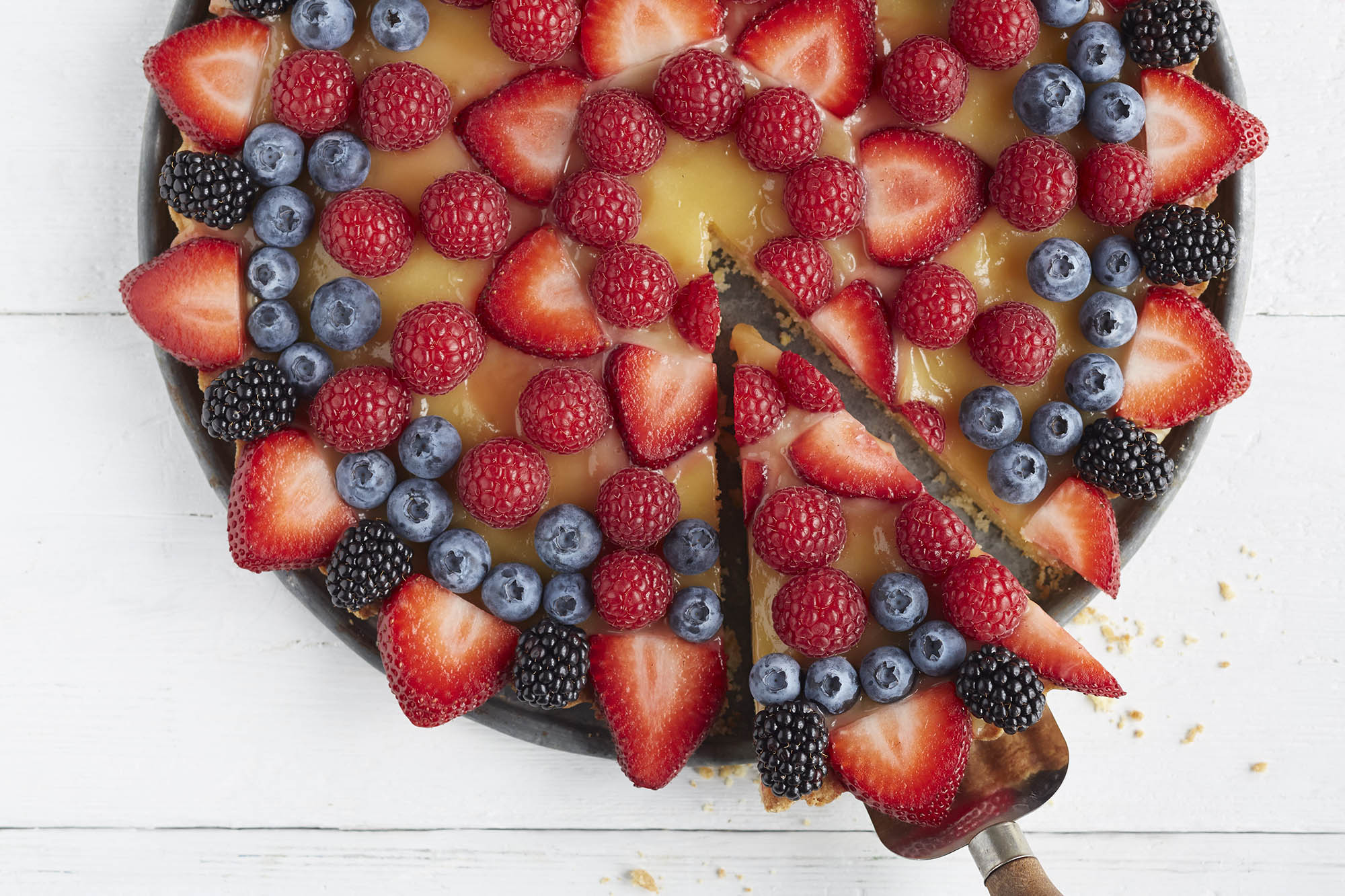 Fruit pizza decorated with berries in a design on top